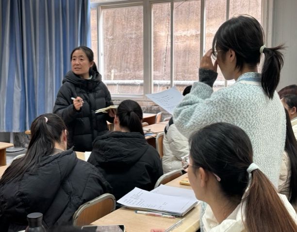 一群人看着桌子上的女人描述已自动生成